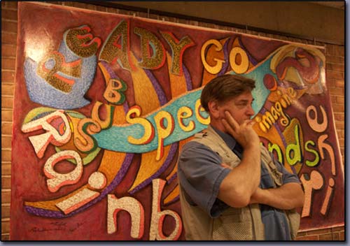James Homer Brown, metro Detroit Michigan artist contemplates next brushstrokes for the Words at Play mural currently on exhibit at the Troy michigan public library